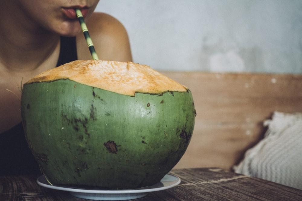Drinking a fresh young coconut water Drinking a fresh young coconut water
