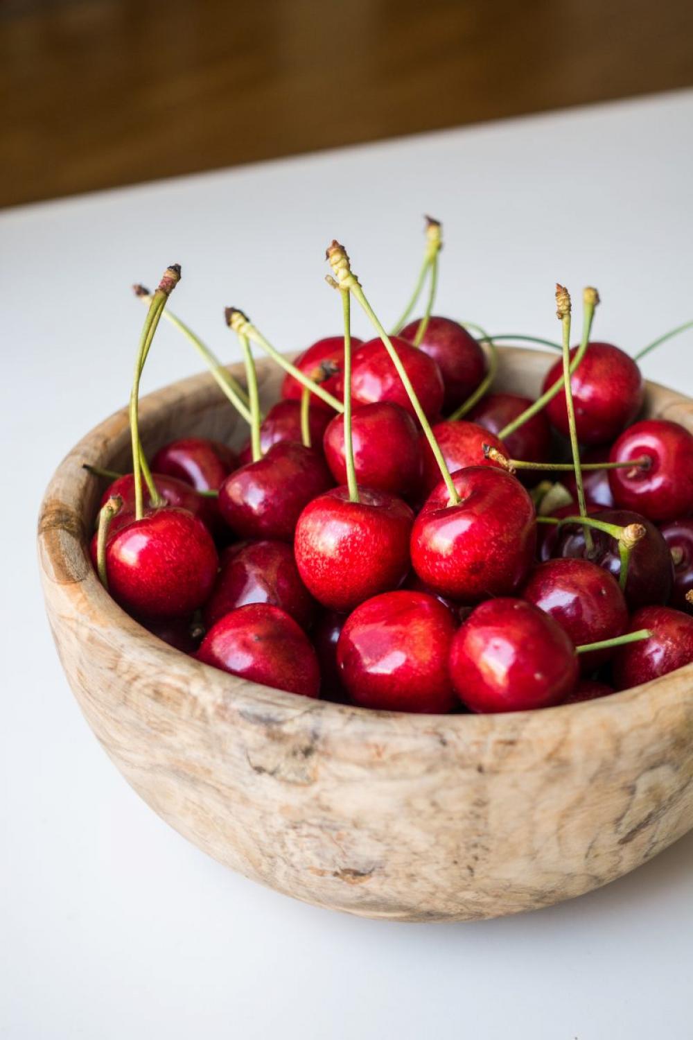 Fresh cherries in a wooden bowl Fresh cherries in a wooden bowl