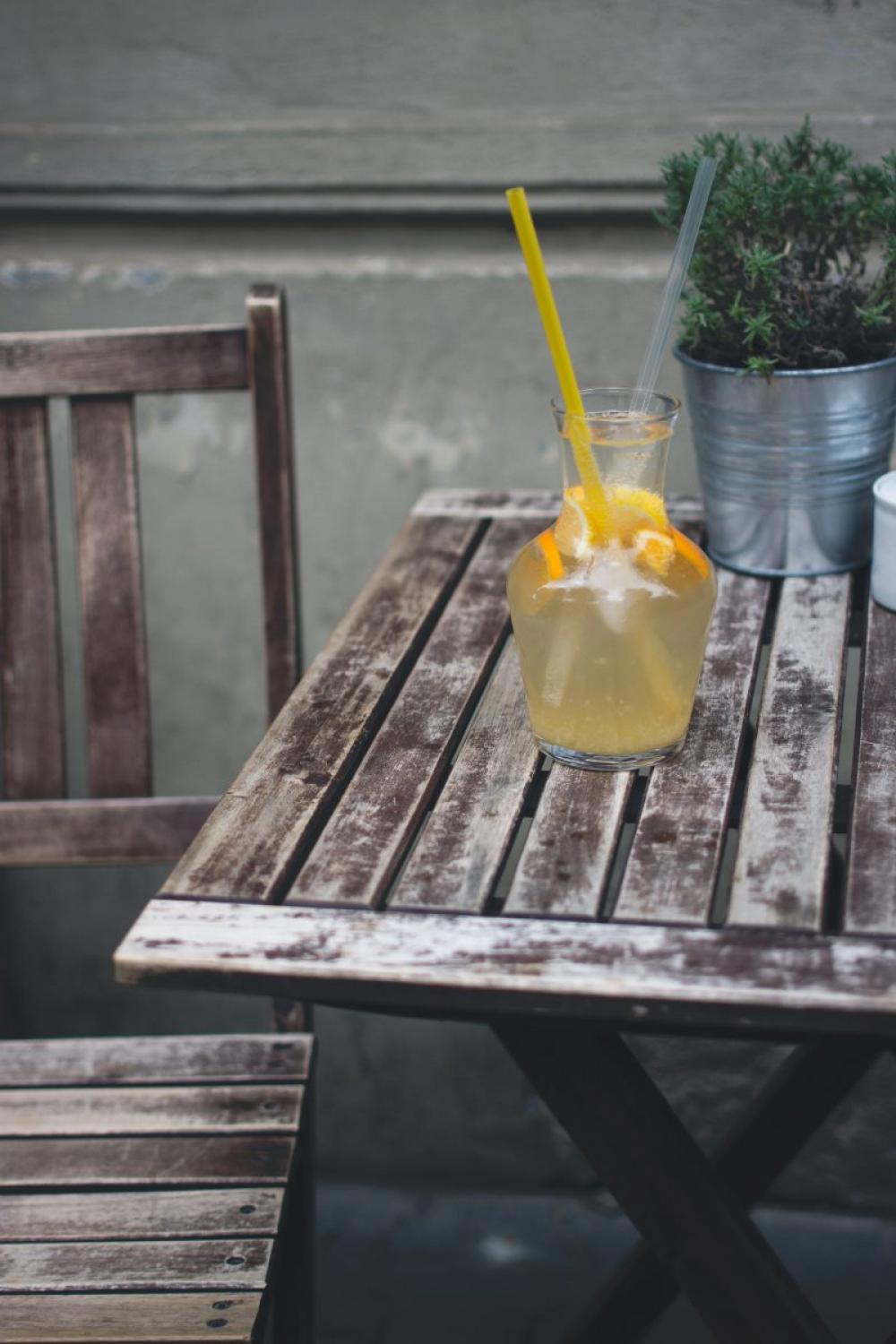 Orange lemonade at a wooden desk outside Orange lemonade at a wooden desk outside