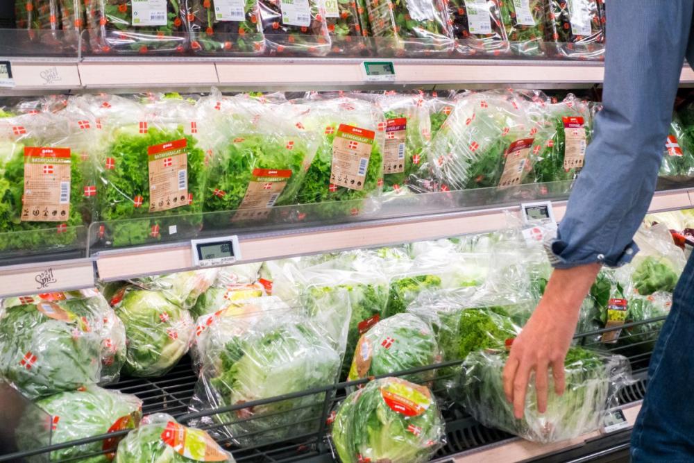 Woman picking lettuce in a grocery store Woman picking lettuce in a grocery store