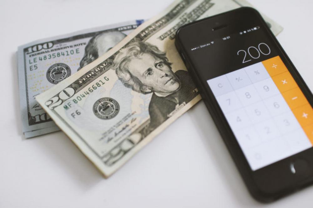 Counting Dollars on calculator on smartphone Counting Dollars on calculator on smartphone