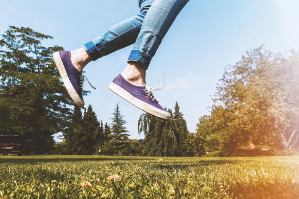 Female legs jumping on the grass outdoors in the park Female legs jumping on the grass outdoors in the park