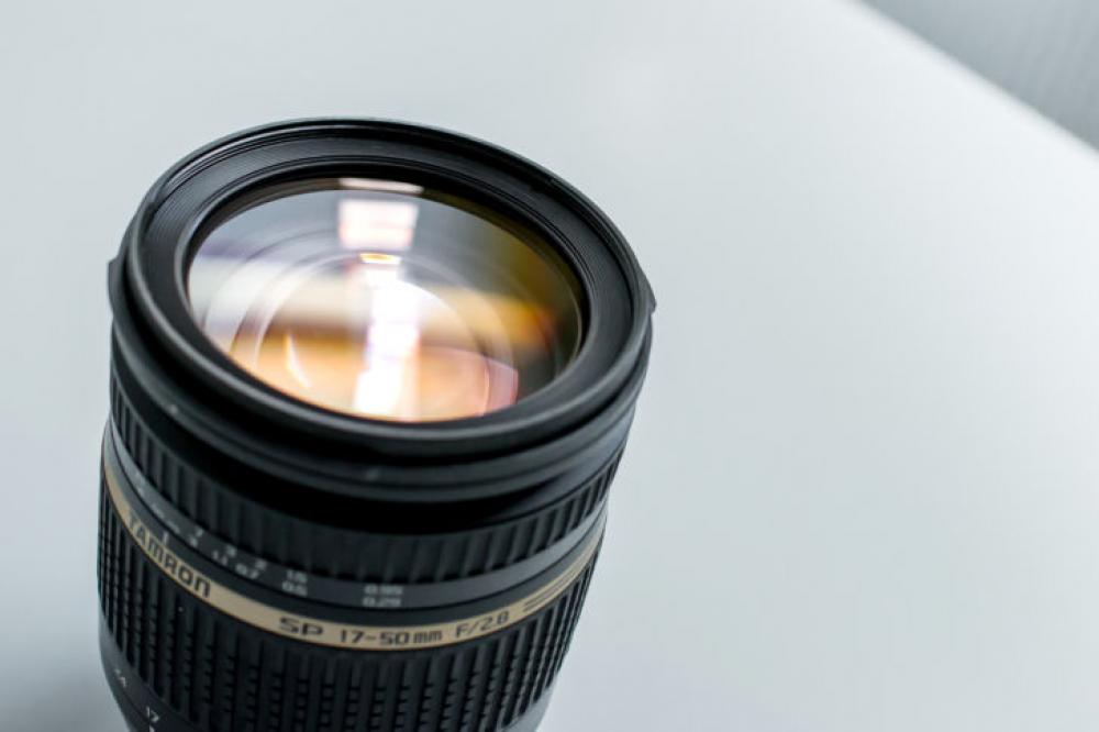 Modern lens on a photographer’s desk Modern lens on a photographer’s desk