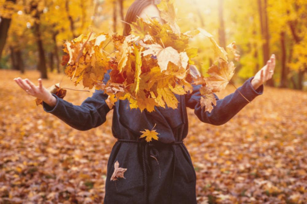 Woman Throwing Autumn Leaves Into The Air Woman Throwing Autumn Leaves Into The Air