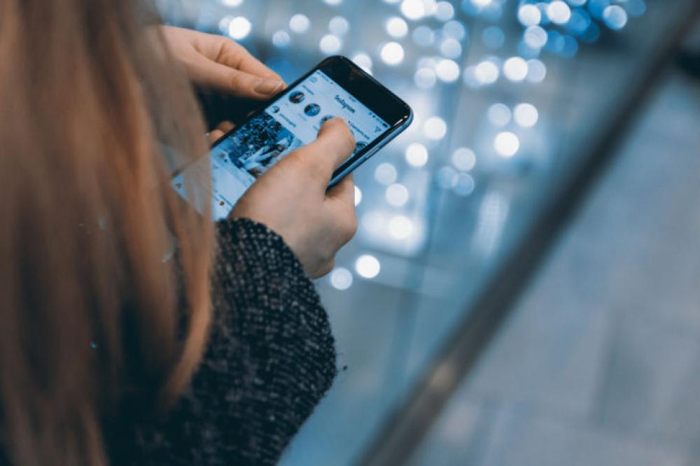 Young girl uses smartphone with Instagram app Young girl uses smartphone with Instagram app
