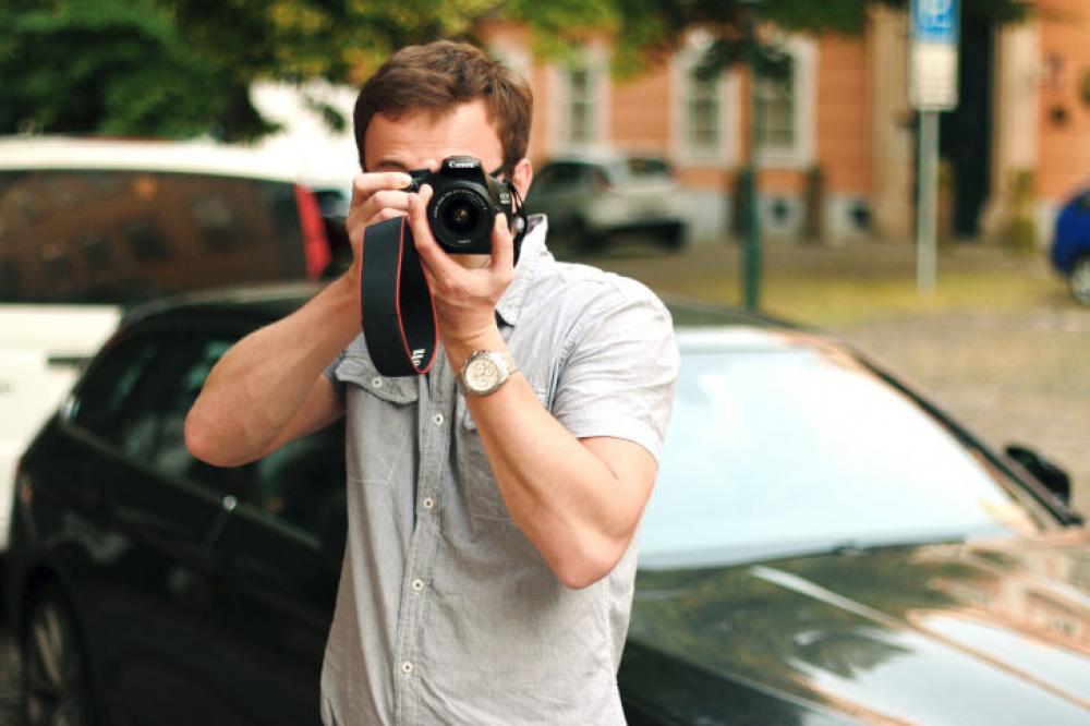 Photographer with a DSLR camera in hand on the street Photographer with a DSLR camera in hand on the street
