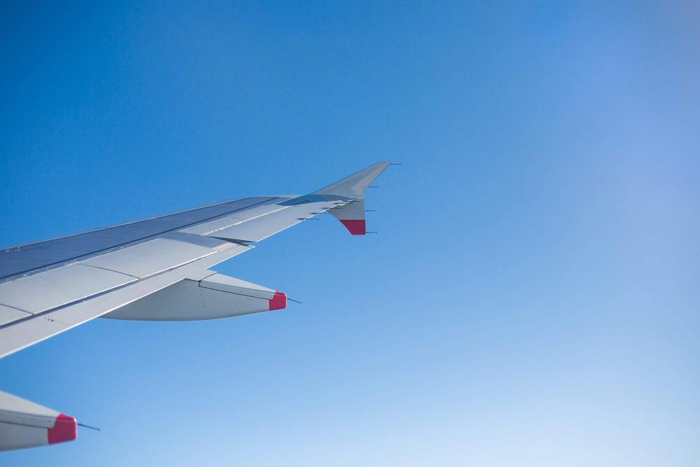 Airplane Wing and Bright Sky Through an Airplane Window Airplane Wing and Bright Sky Through an Airplane Window