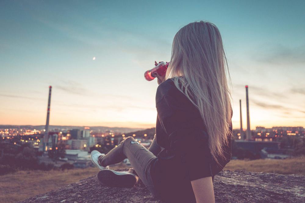 Young Woman Drinking Lemonade and Overlooking the City Young Woman Drinking Lemonade and Overlooking the City
