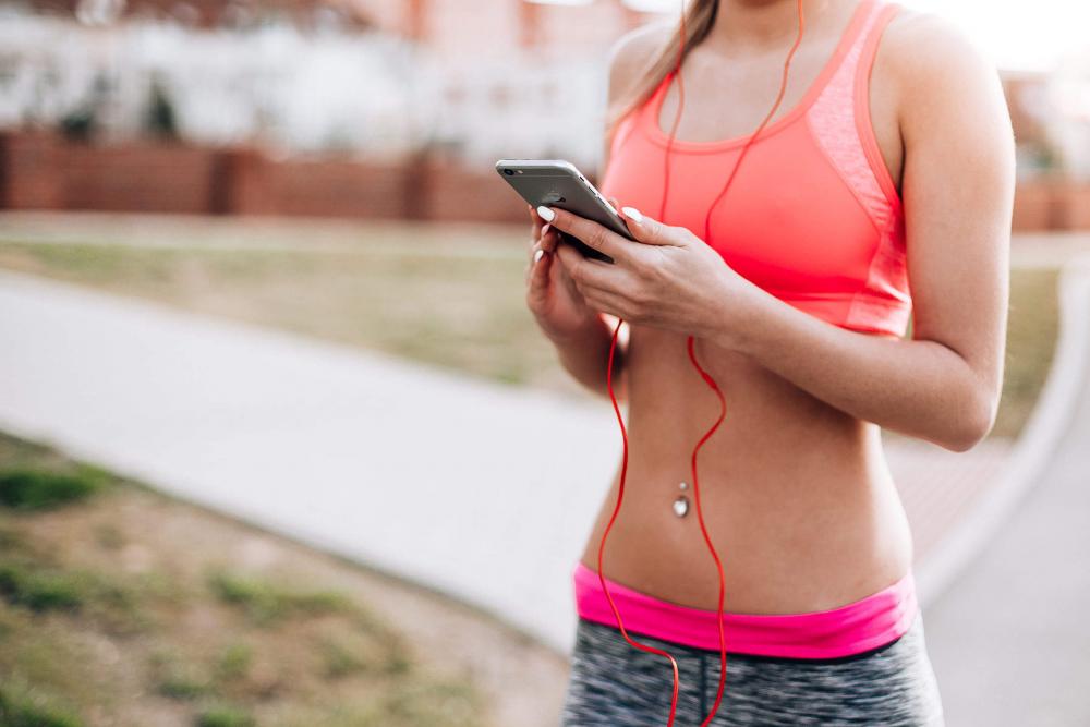 Fitness Girl Listening to Streaming Music on Her Phone Fitness Girl Listening to Streaming Music on Her Phone