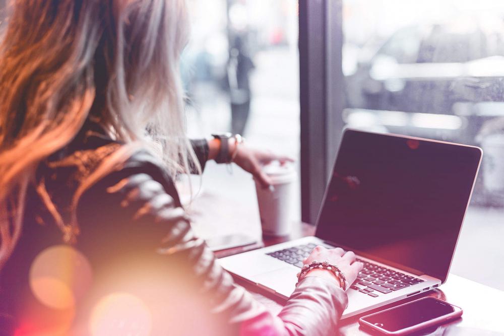 Young Freelance Woman Working Remotely from Café Young Freelance Woman Working Remotely from Café
