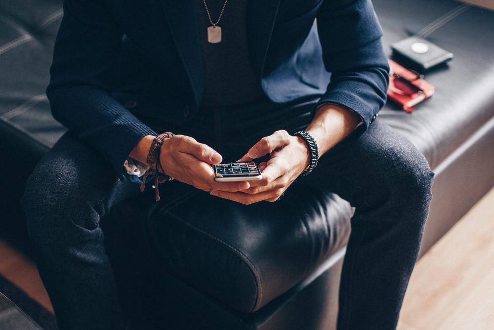 Man Using his iPhone 6 on a Sofa Man Using his iPhone 6 on a Sofa