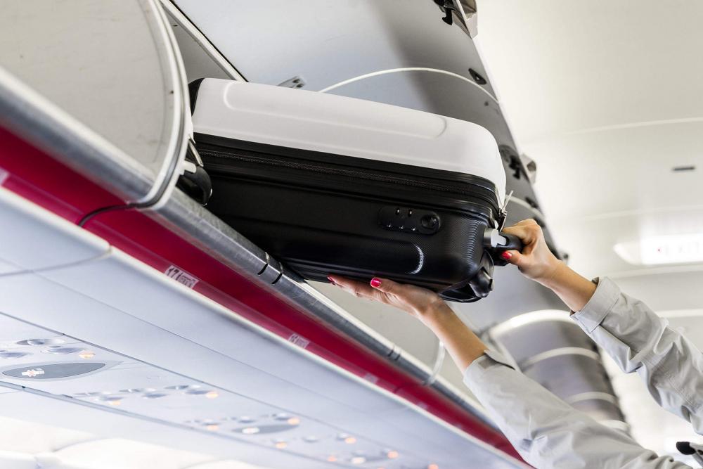 Woman Taking Her Hand Luggage in Airplane Woman Taking Her Hand Luggage in Airplane