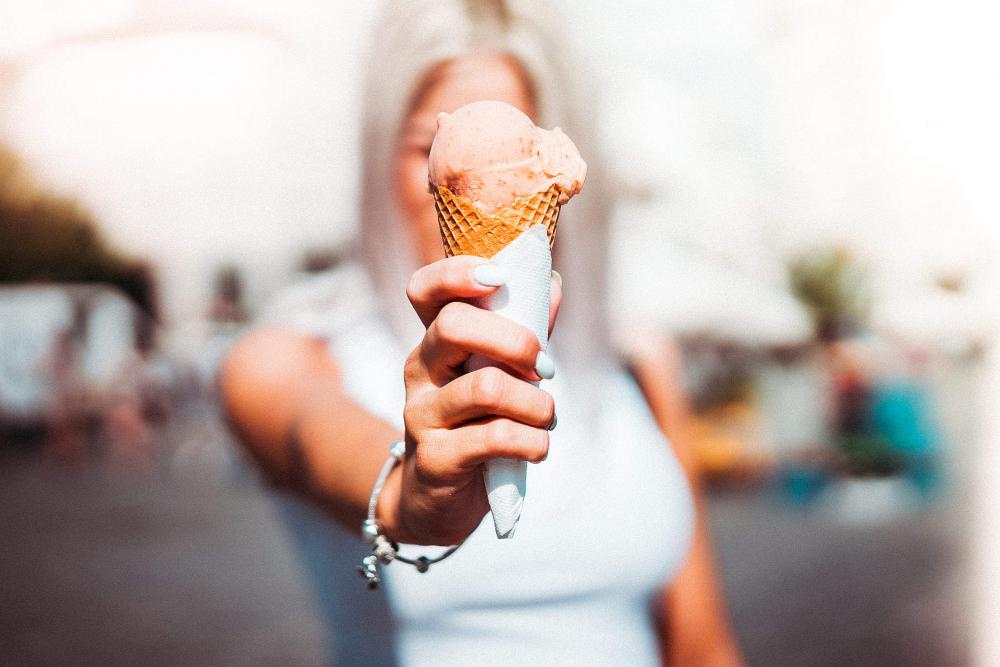 Woman Holding an Ice Cream in Front of Her Face Woman Holding an Ice Cream in Front of Her Face
