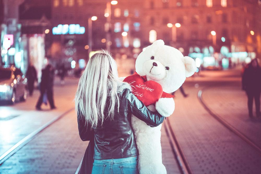 Young Woman Walking with a Big Teddy Bear at Night Young Woman Walking with a Big Teddy Bear at Night