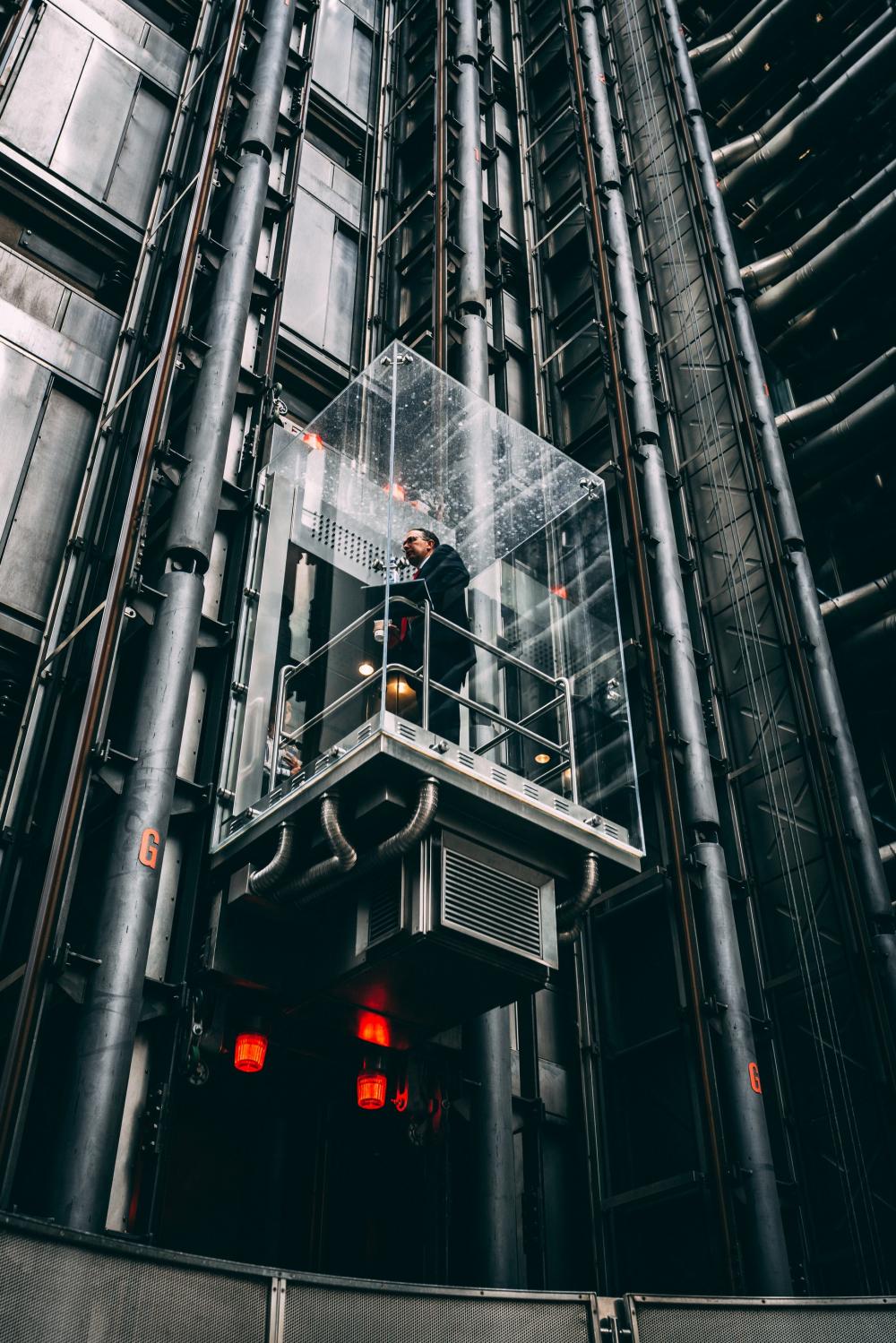 Businessman In Glass Elevator Going Up Photo Businessman In Glass Elevator Going Up Photo