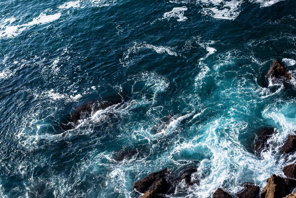 Foaming Blue Water Rolls Over Rocks Photo Foaming Blue Water Rolls Over Rocks Photo