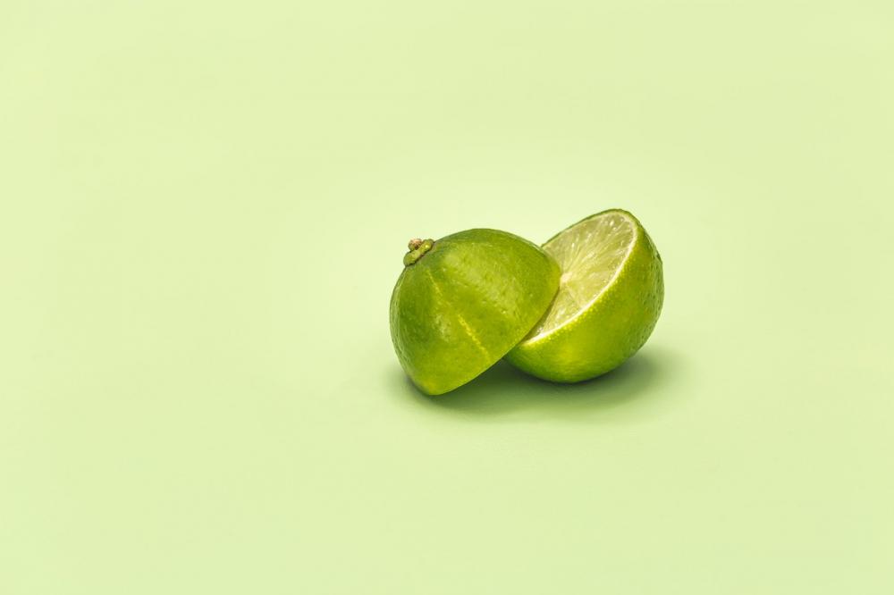 Lime Cut In Half On Green Surface Photo Lime Cut In Half On Green Surface Photo