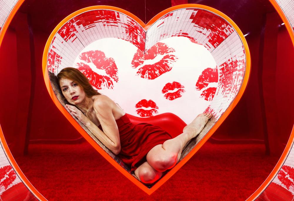 Woman In Red Dress Rests Her Head On The Walls Of Heart Display Photo Woman In Red Dress Rests Her Head On The Walls Of Heart Display Photo