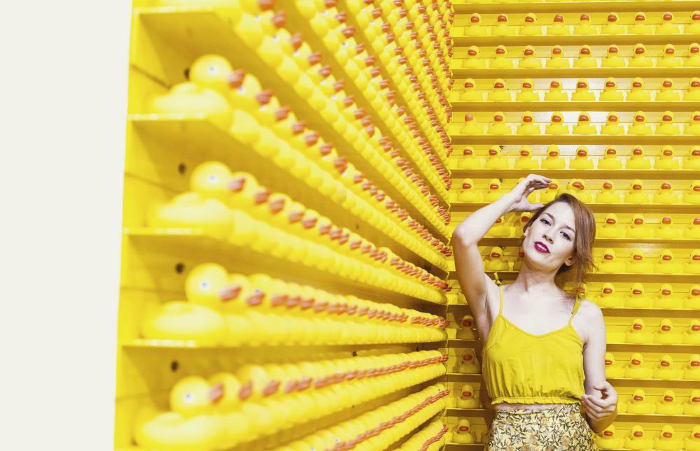 Woman In Yellow Stands Before A Wall Of Rubber Ducks Photo Woman In Yellow Stands Before A Wall Of Rubber Ducks Photo