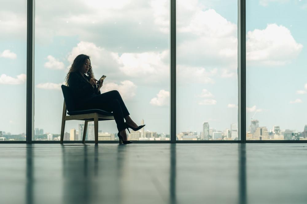 Woman Sitting On Phone In Modern Office Chair Photo Woman Sitting On Phone In Modern Office Chair Photo