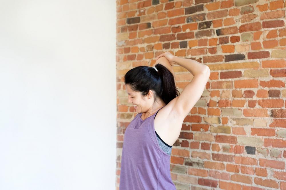 Young Woman Exercising In Workout Clothes Against Brick Wall Photo Young Woman Exercising In Workout Clothes Against Brick Wall Photo