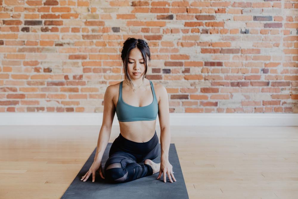 Young Woman In Yoga Pose Against Exposed Brick Photo Young Woman In Yoga Pose Against Exposed Brick Photo