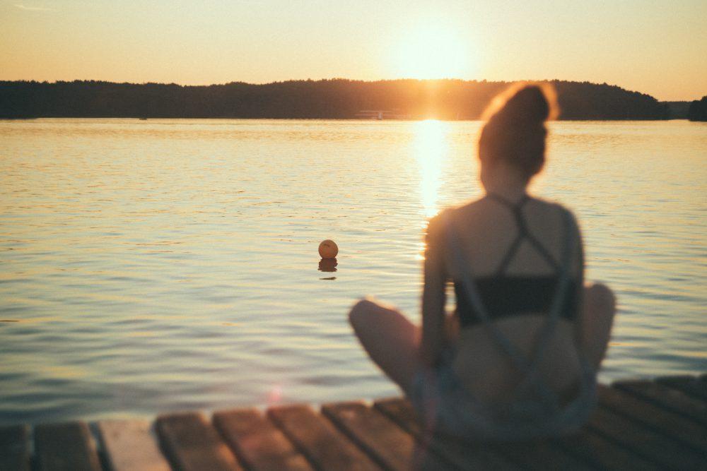 A girl sitting on a pier blurred A girl sitting on a pier blurred