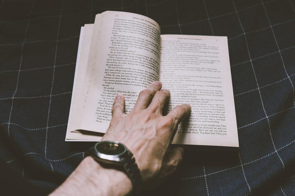 Male hand holding an open book Male hand holding an open book
