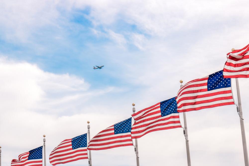 Plane flying above a bunch of USA Flags free photo Plane flying above a bunch of USA Flags free photo