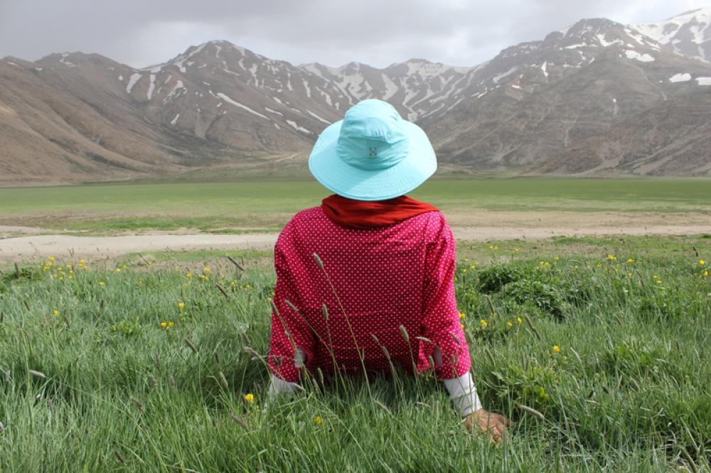 Women sitting on grass looking at landscape free photo Women sitting on grass looking at landscape free photo