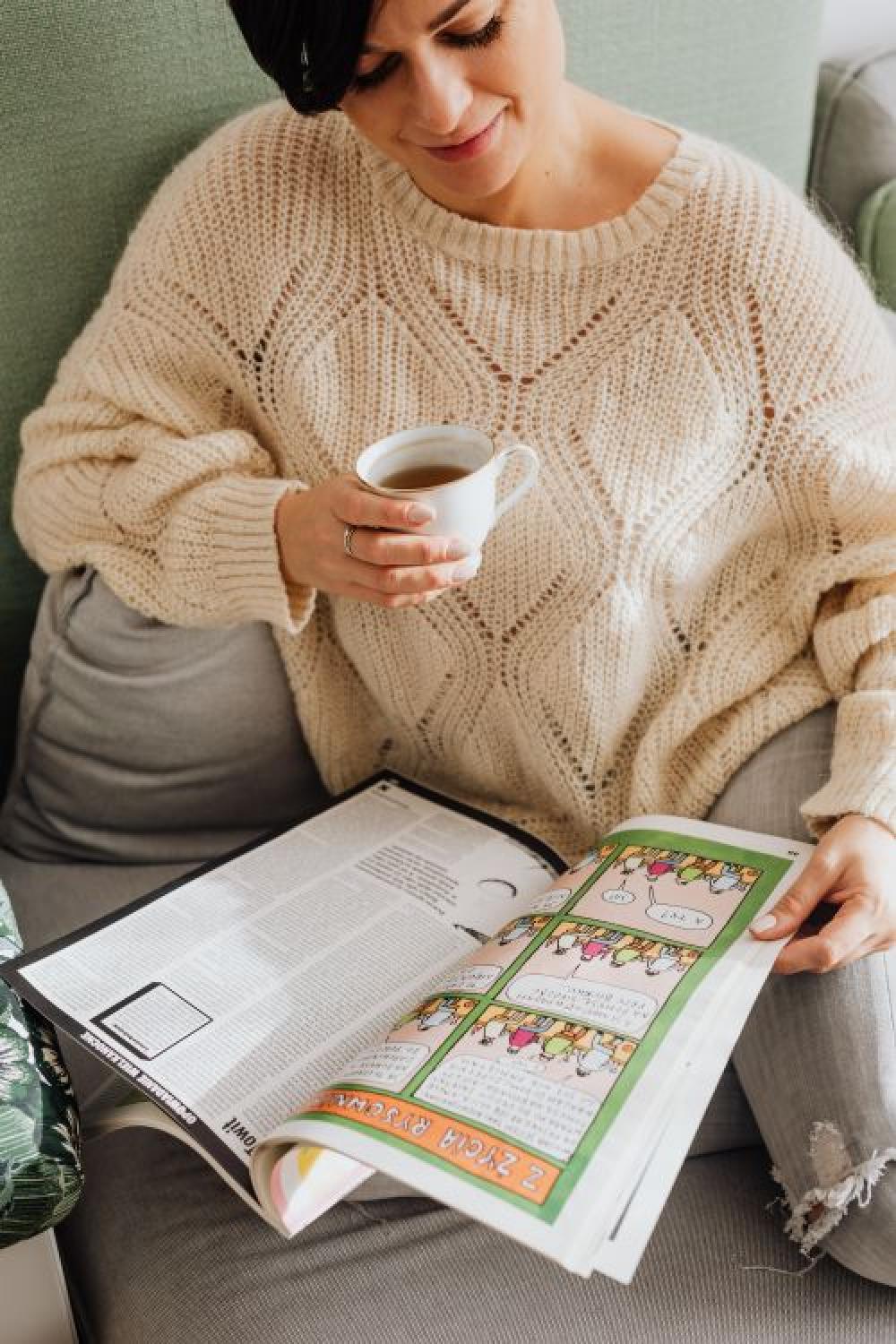 The woman is sitting on a comfortable sofa in the house The woman is sitting on a comfortable sofa in the house