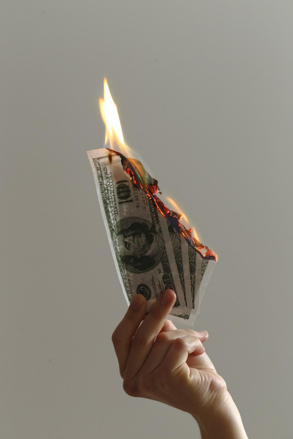 A Single Hand Holding Up Burning Notes Photo A Single Hand Holding Up Burning Notes Photo