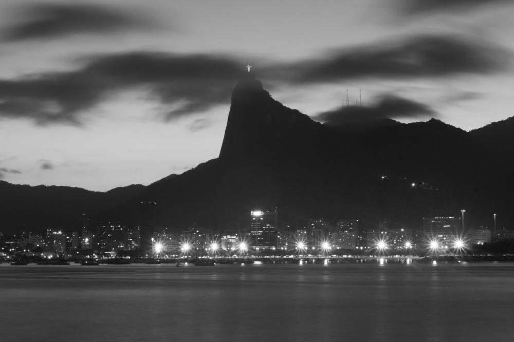 A Statue Of Jesus Overlooks The City Lights At Night Photo A Statue Of Jesus Overlooks The City Lights At Night Photo