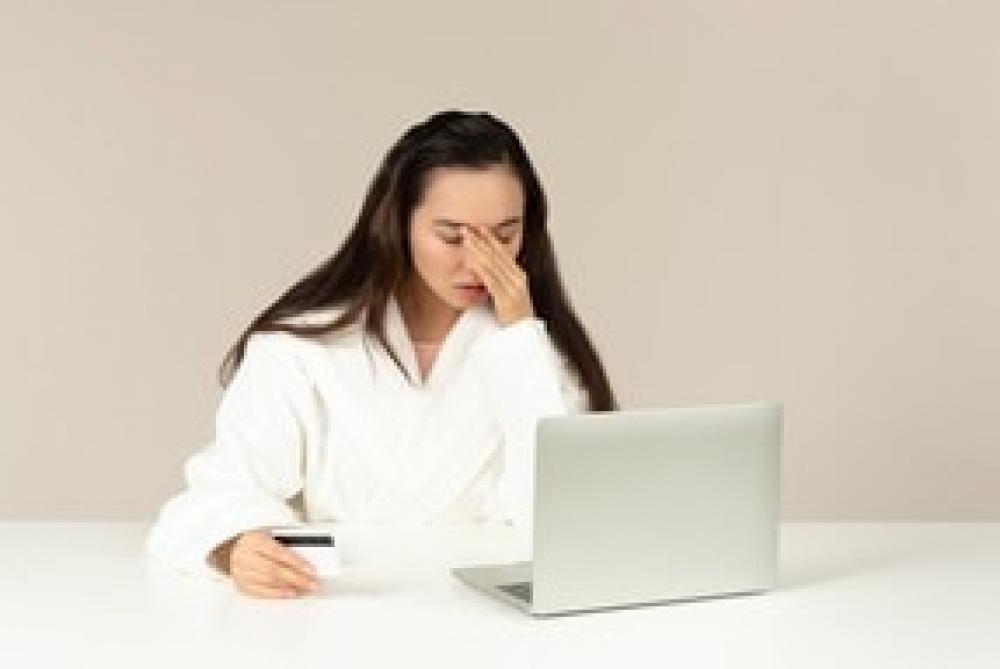 Young Asian Woman Looking Upset While Doing Online Shopping Young Asian Woman Looking Upset While Doing Online Shopping