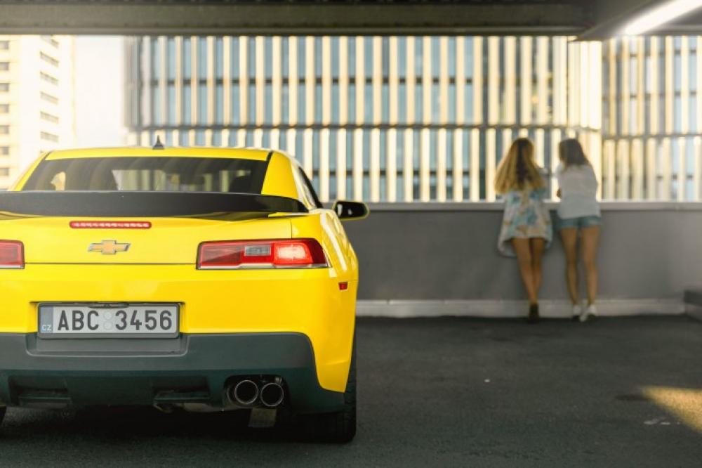 Luxury car parked in garage. Two young girls near the car. Luxury car parked in garage. Two young girls near the car.