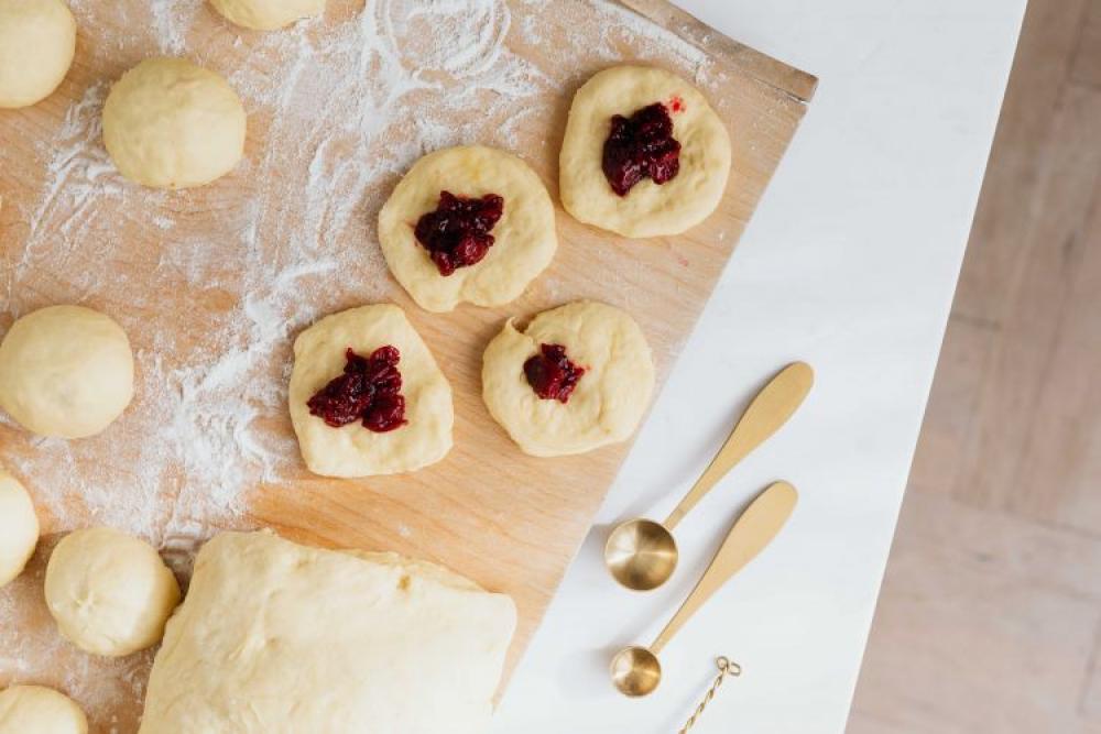 Adding cherry marmalade to Polish donuts - Paczki Adding cherry marmalade to Polish donuts - Paczki