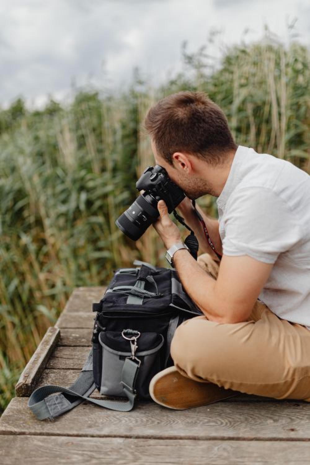 Photographer holding a DSLR camera Photographer holding a DSLR camera
