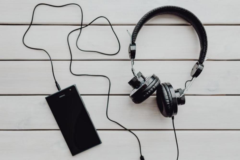 Black smartphone and headphones with various items Black smartphone and headphones with various items