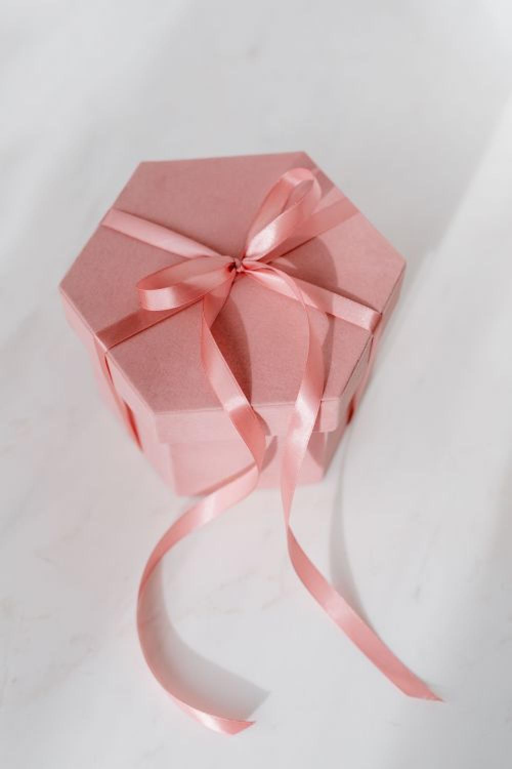 Light pink velvety box with satin ribbon on white marble Light pink velvety box with satin ribbon on white marble