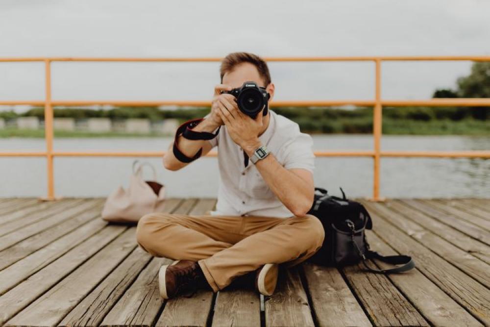 Photographer holding a DSLR camera Photographer holding a DSLR camera