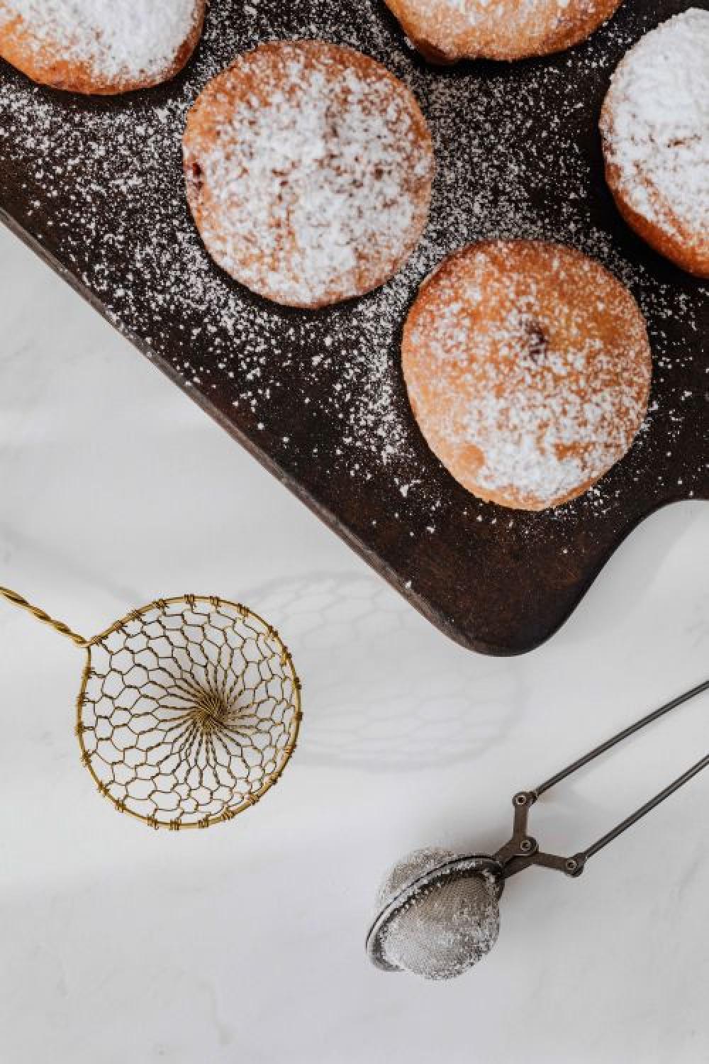 Homemade doughnuts covered with powdered sugar. Fat Thursday in Poland. Homemade doughnuts covered with powdered sugar. Fat Thursday in Poland.