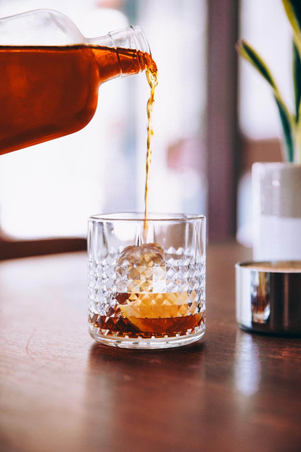 bourbon pouring glass on the rocks ice bourbon pouring glass on the rocks ice