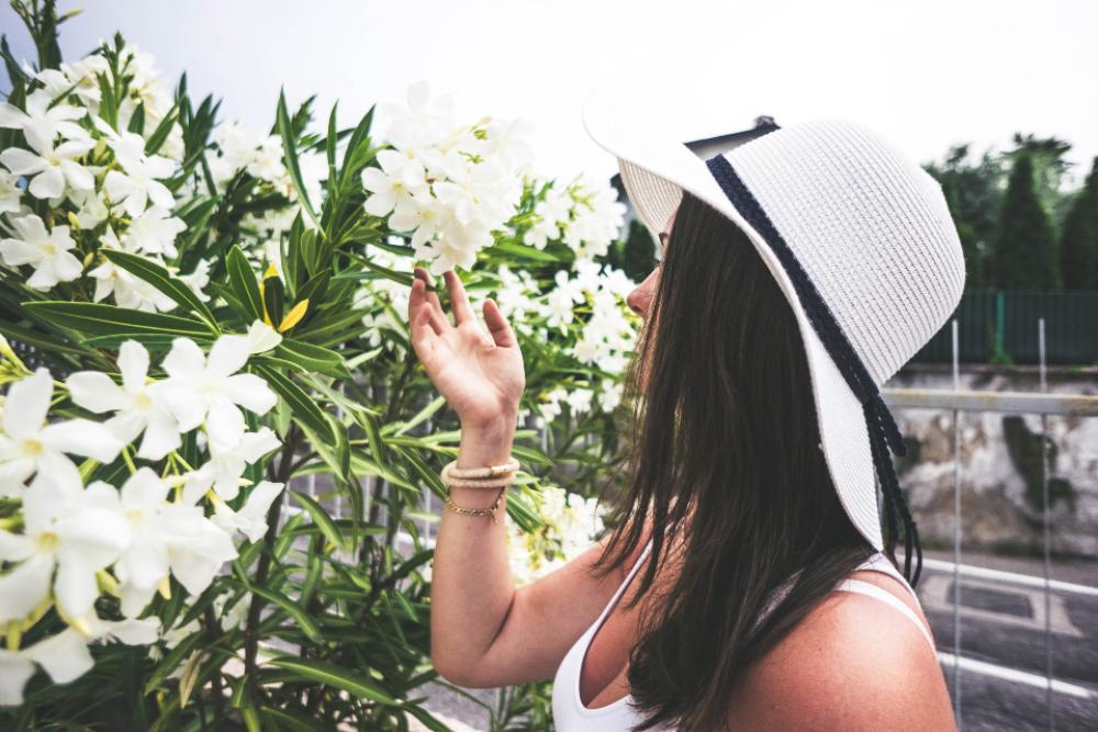 woman smelling flowers nature hat woman smelling flowers nature hat