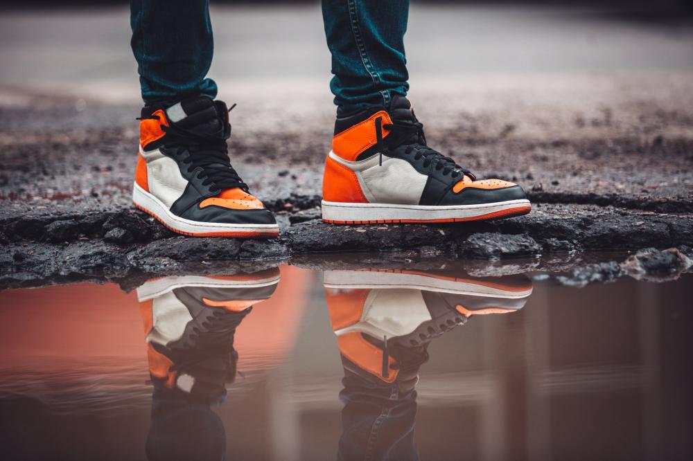 Bright Fashion Sneakers Reflect In Puddle On Asphalt Street Photo Bright Fashion Sneakers Reflect In Puddle On Asphalt Street Photo