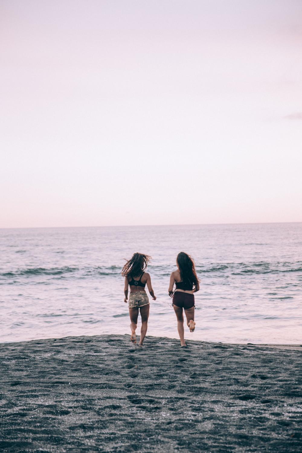 Two Women Run Along A Sunset Beach Photo Two Women Run Along A Sunset Beach Photo
