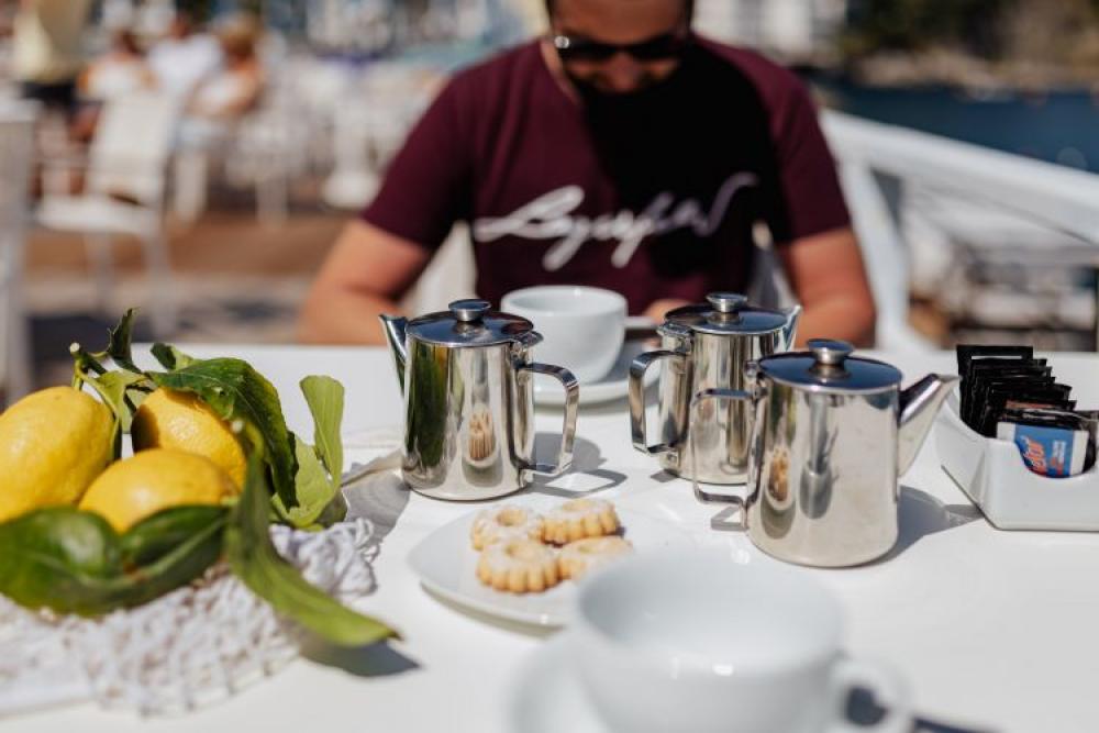 Pouring coffee into a cup. Silver kettles, Italian cookies. Pouring coffee into a cup. Silver kettles, Italian cookies.