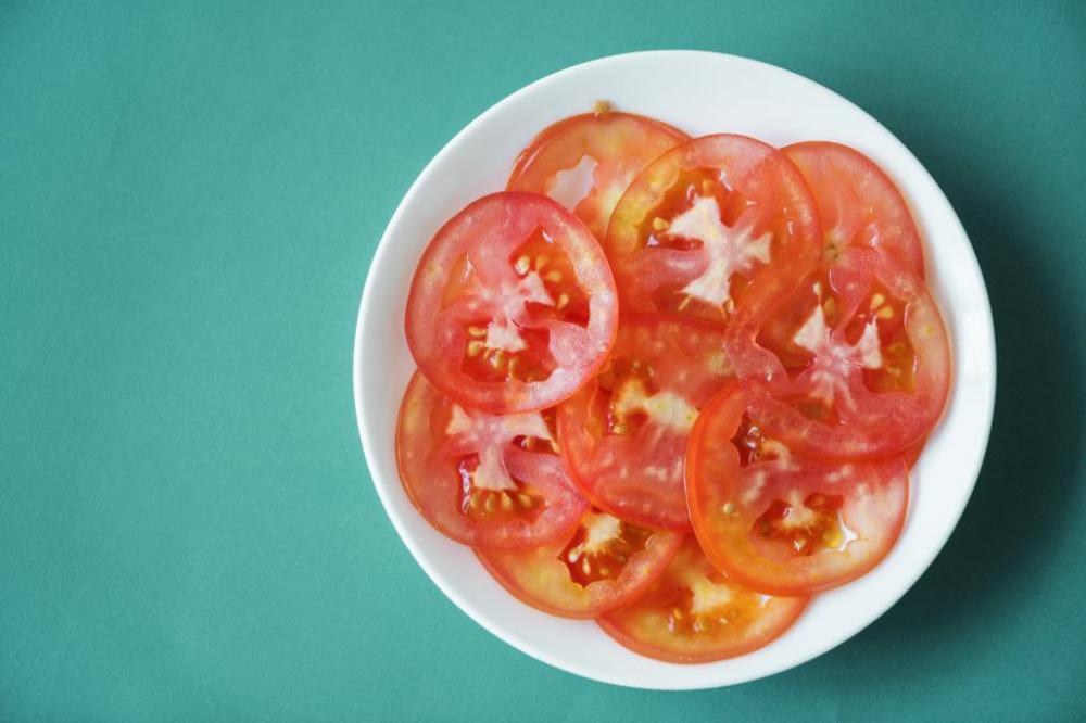 Close up of tomato slices on white plate Close up of tomato slices on white plate