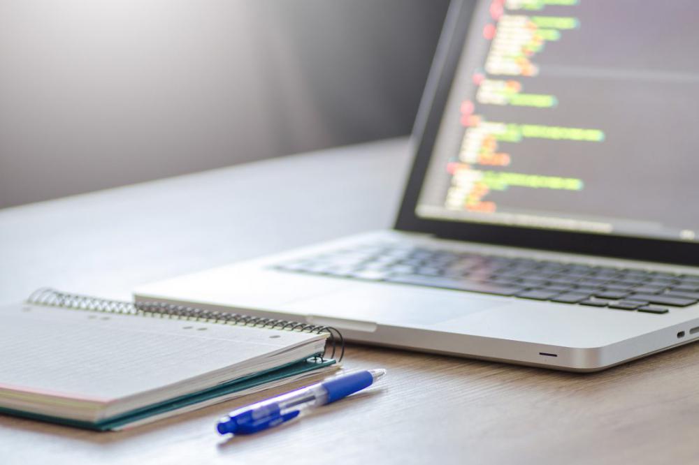 Coding on MacBook Laptop & Notepad Coding on MacBook Laptop & Notepad