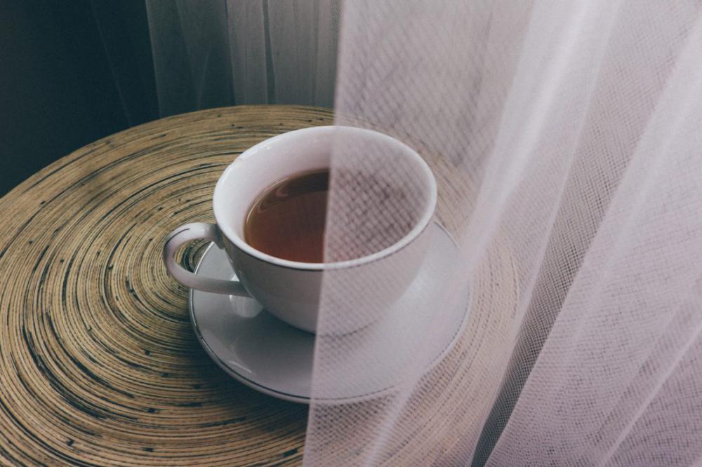 Cup of Tea & Saucer on Round Wooden Table Cup of Tea & Saucer on Round Wooden Table