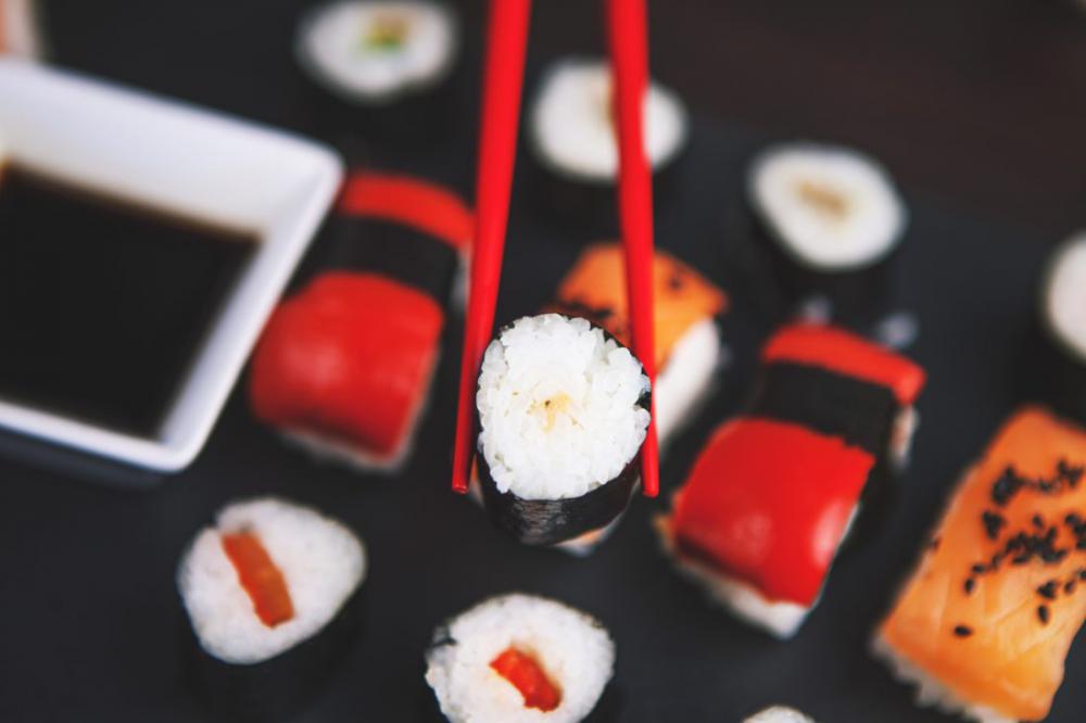 Sushi Held in Chopsticks Sushi Held in Chopsticks